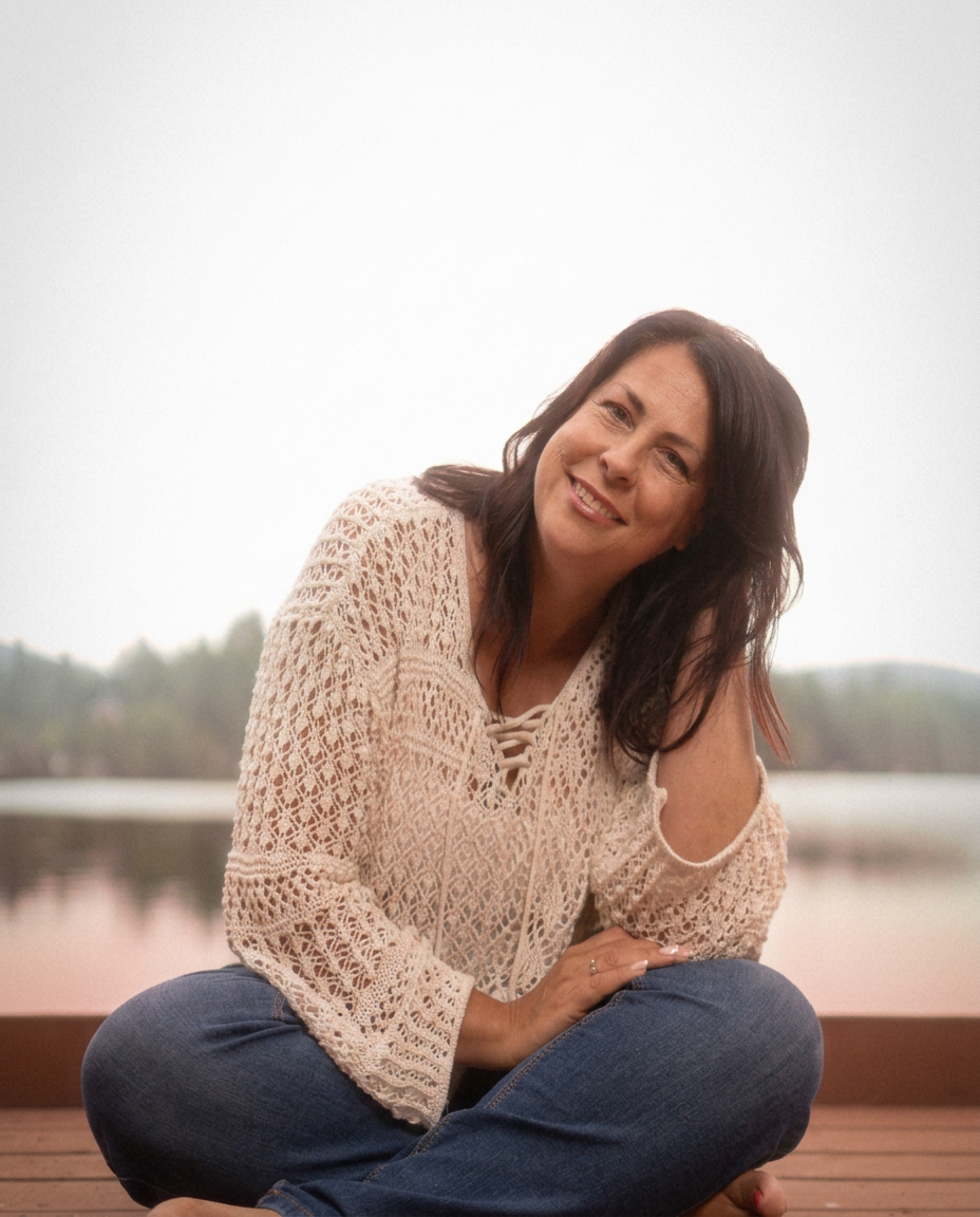 Nancy Doyon souriante, assise sur un quai au bord du fjord
